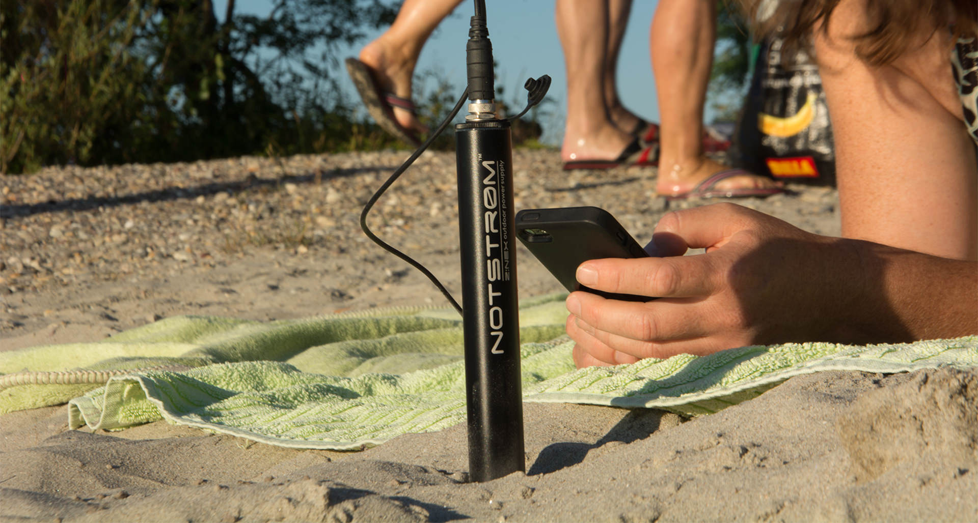 Wasser und staubdichte Powerbank Notstrøm XT im Sand eines Badestrandes